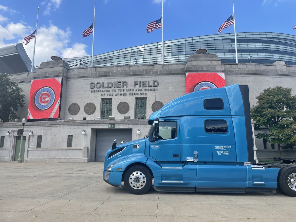 Absolute Trucking blue semi truck parked outside Soldier Field in Chicago